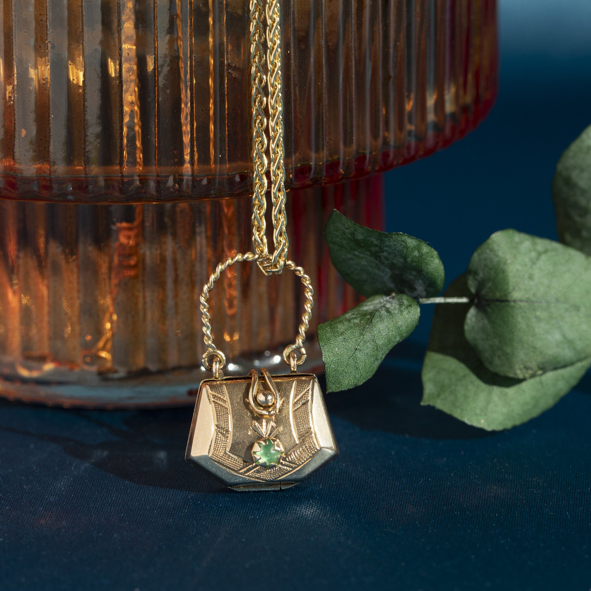 14 kt gold bag pendant with a small glass stone