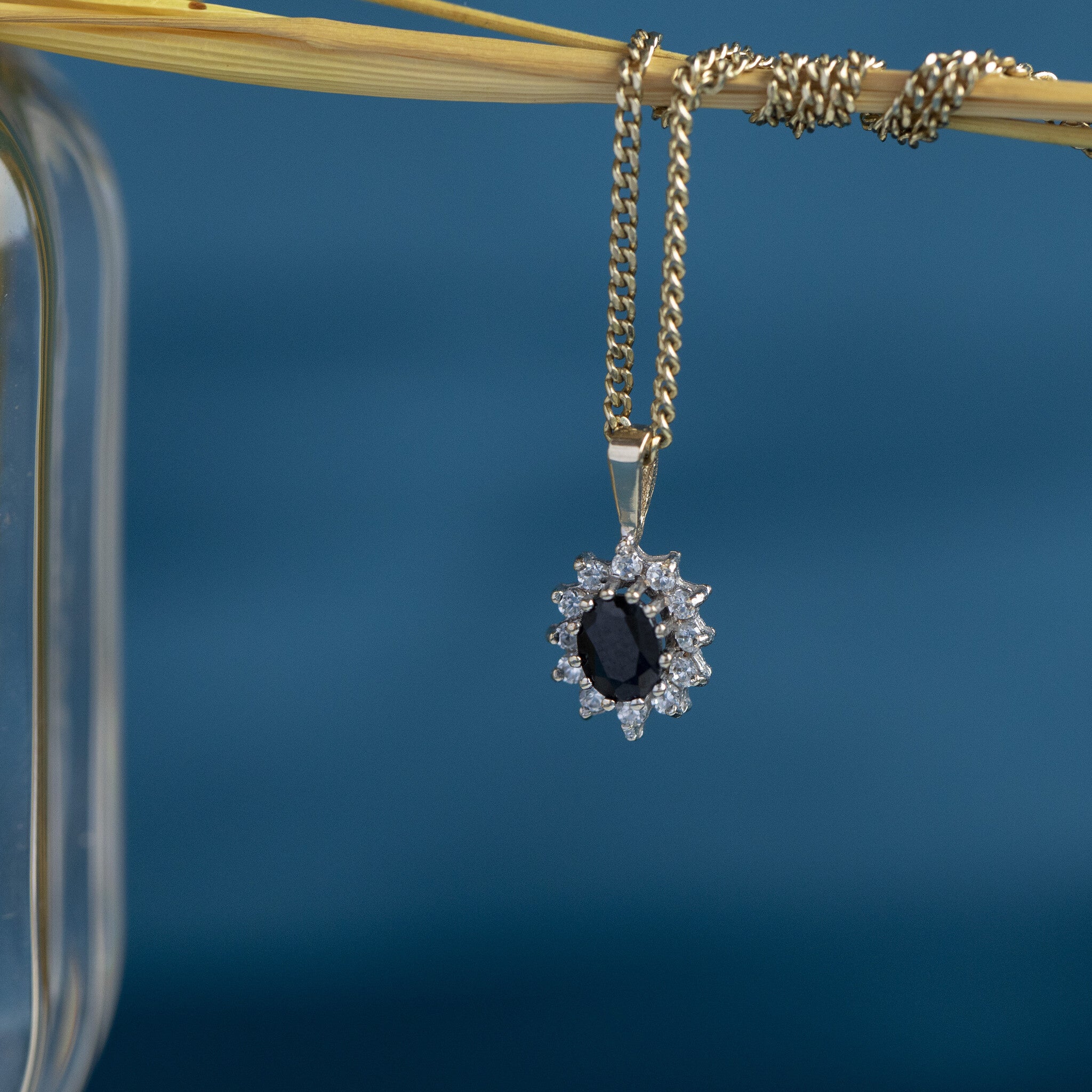 14 kt gold entourage pendant with sapphire and zirconia
