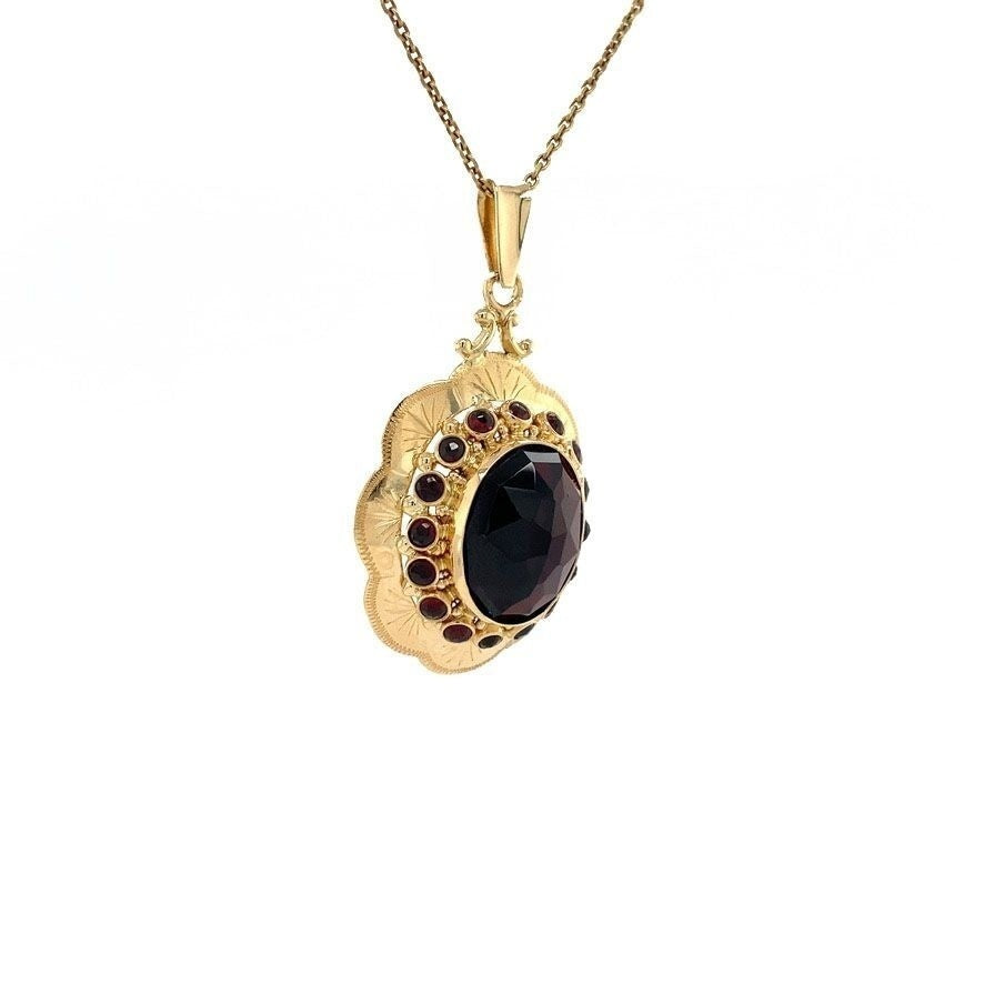 Gold entourage pendant with garnet 14 kt