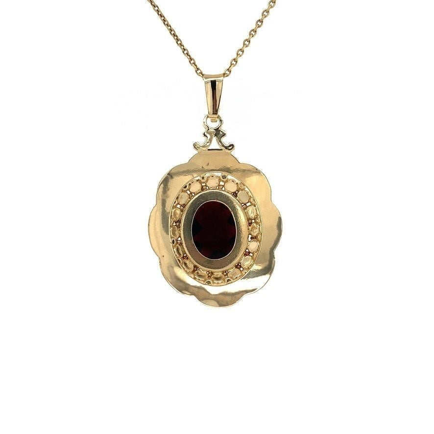 Gold entourage pendant with garnet 14 kt