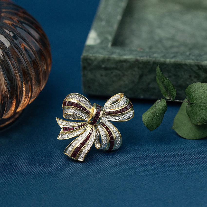 Gouden strik broche met robijn en diamant 18 krt