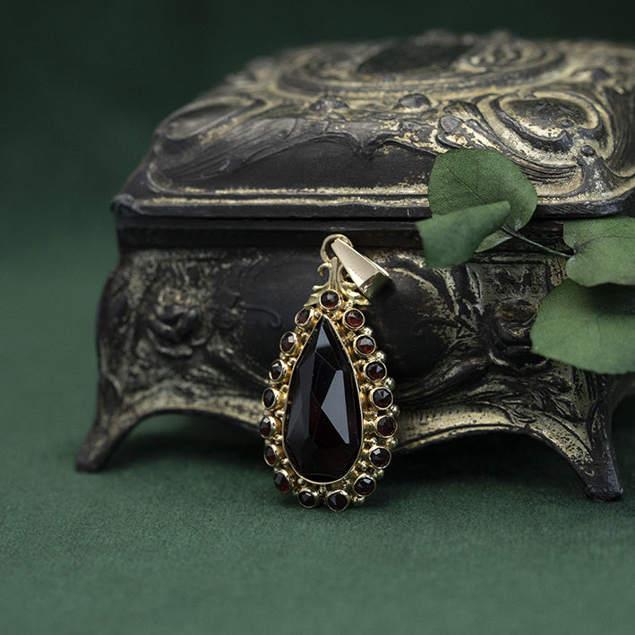 Gouden entourage hanger met granaat 14 krt