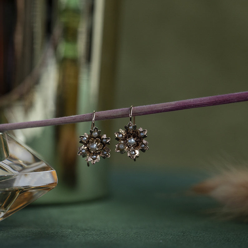 Gouden bloem oorhangers met parel 14 krt