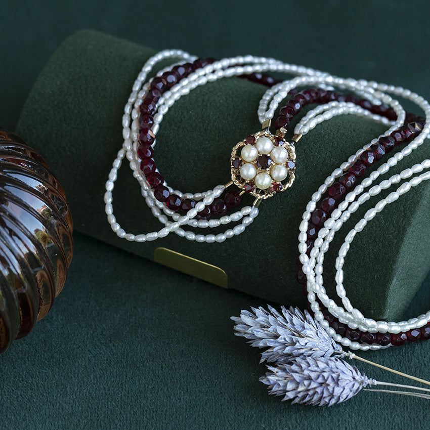 Vintage pearl and colored-gemstone necklace with double halo decorative clasp set with garnet and pearl, 9 kt