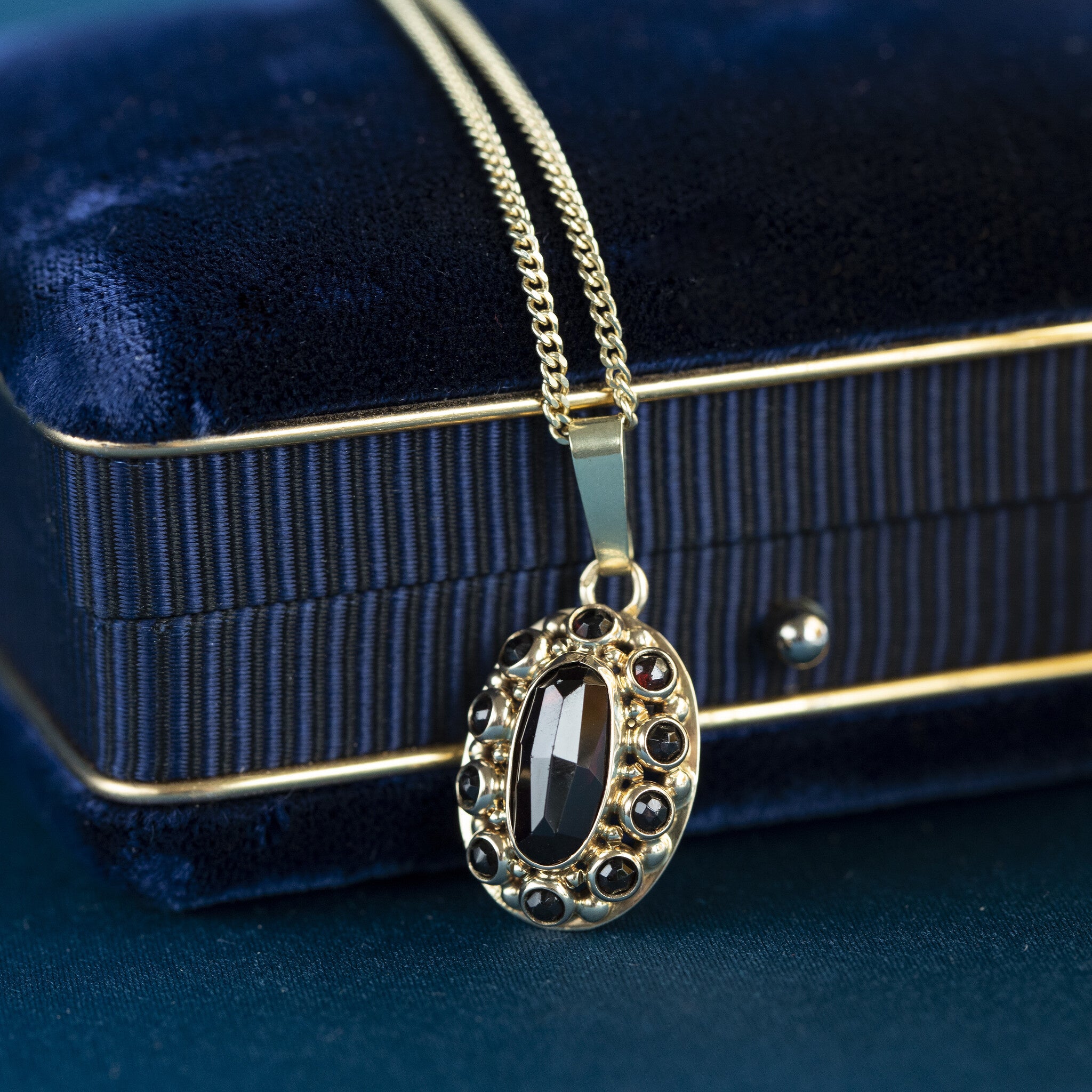 Gold entourage pendant with garnet 14 kt