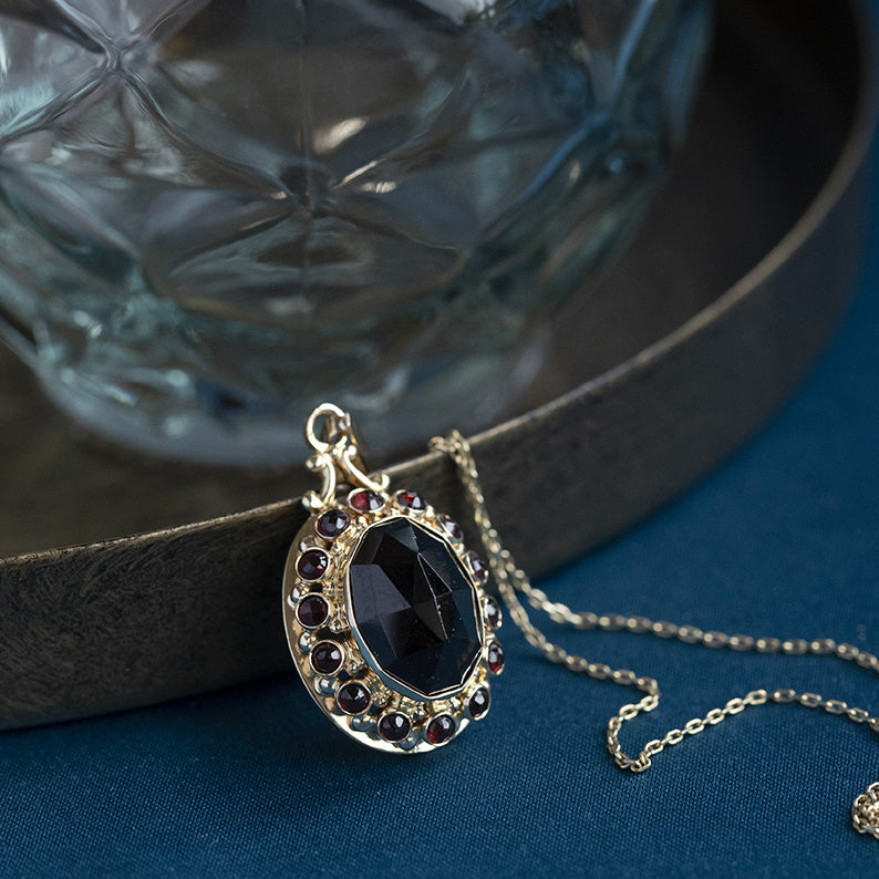 Gold entourage pendant with garnet 14 kt